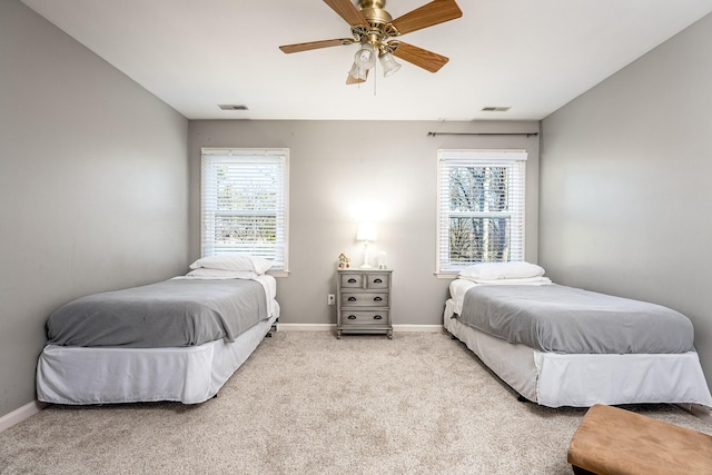 bedroom featuring multiple windows, light colored carpet, and ceiling fan