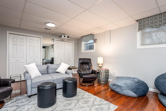 living room with hardwood / wood-style flooring and a drop ceiling