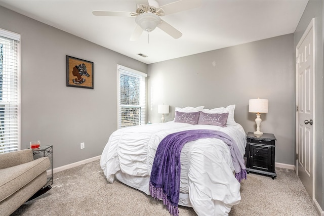 carpeted bedroom with multiple windows and ceiling fan