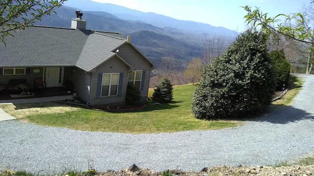 view of side of home featuring a mountain view and a yard