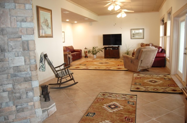 living room with light tile patterned floors, ornamental molding, and ceiling fan