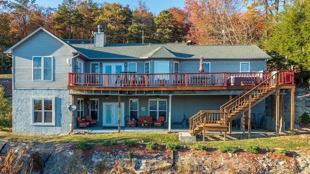 back of house with a wooden deck and a patio