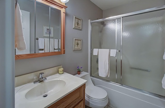 full bathroom with vanity, bath / shower combo with glass door, and toilet