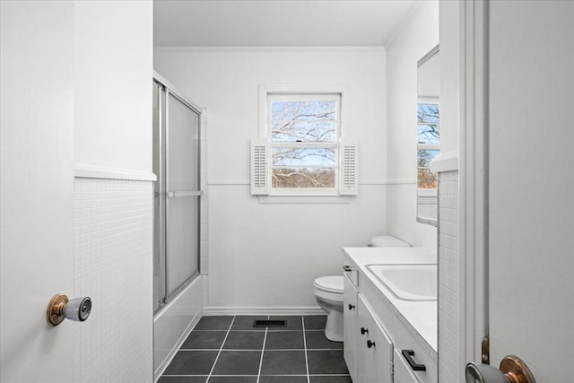 full bathroom featuring toilet, bath / shower combo with glass door, tile patterned floors, ornamental molding, and vanity