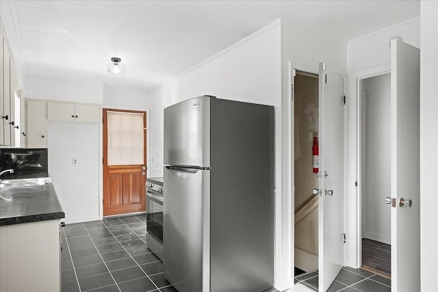 kitchen featuring sink, dark tile patterned flooring, white cabinets, and stainless steel appliances