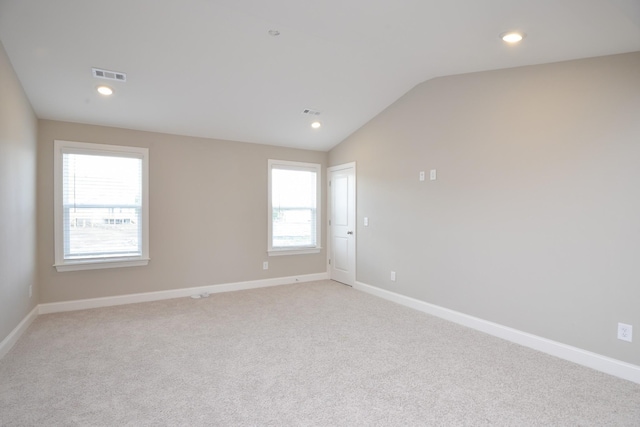 unfurnished room with light carpet and lofted ceiling