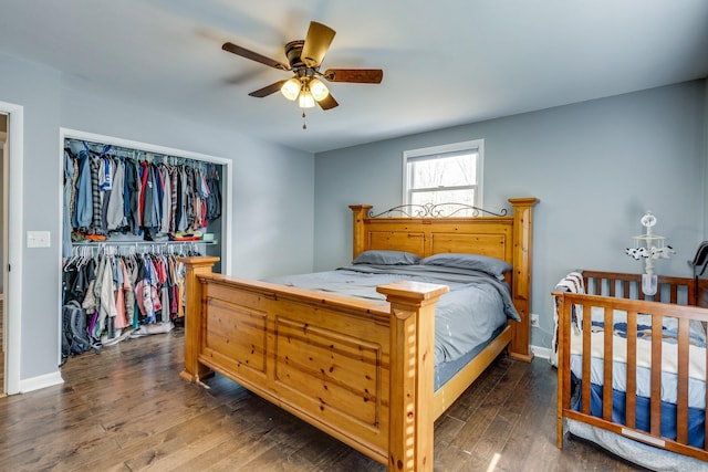 bedroom with dark wood-type flooring, a closet, and ceiling fan