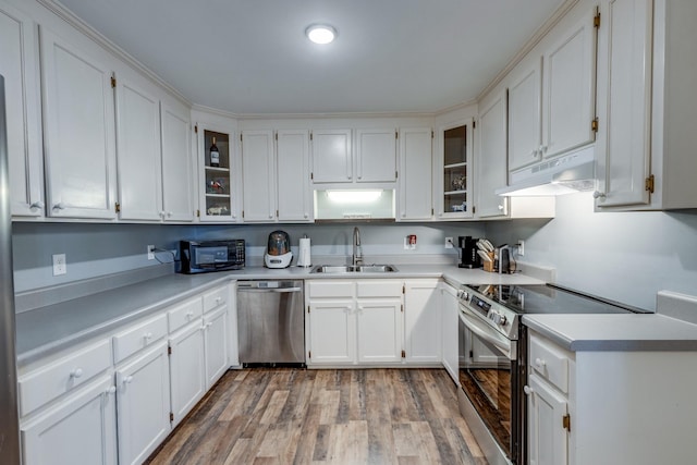 kitchen featuring sink, white cabinets, wood-type flooring, and appliances with stainless steel finishes