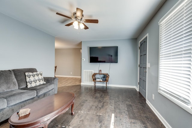 living room with ceiling fan and dark hardwood / wood-style flooring