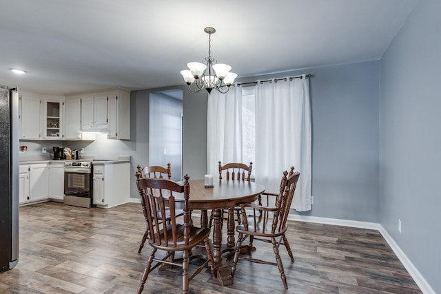 dining room with dark wood-type flooring and a chandelier