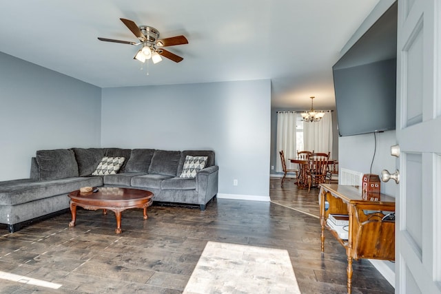 living room with ceiling fan with notable chandelier and dark hardwood / wood-style flooring