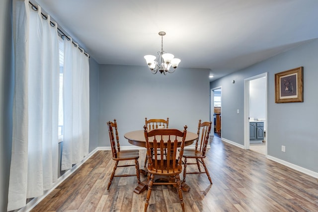 dining room with hardwood / wood-style floors and an inviting chandelier