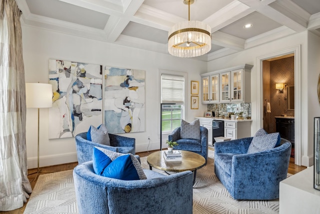 living area featuring beamed ceiling, bar, light hardwood / wood-style flooring, crown molding, and coffered ceiling