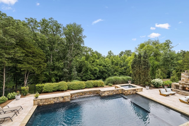 view of swimming pool featuring an in ground hot tub, an outdoor stone fireplace, and a patio