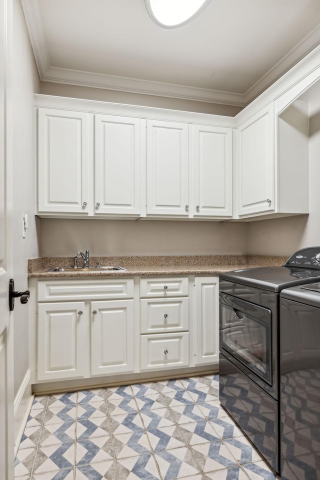 laundry area featuring sink, cabinets, separate washer and dryer, and crown molding