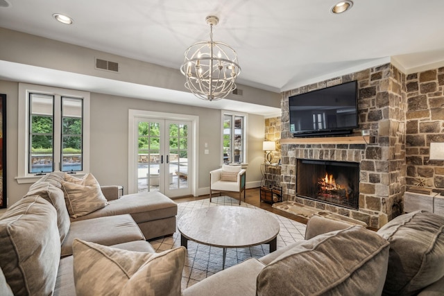 living room featuring a fireplace, hardwood / wood-style flooring, a chandelier, and french doors