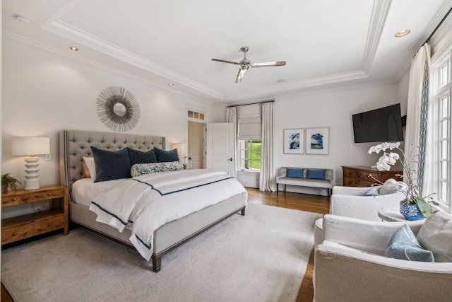 bedroom featuring ceiling fan, dark wood-type flooring, ornamental molding, and a raised ceiling