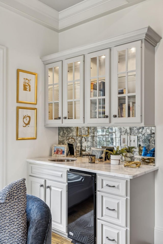 bar featuring crown molding, sink, white cabinets, decorative backsplash, and beverage cooler