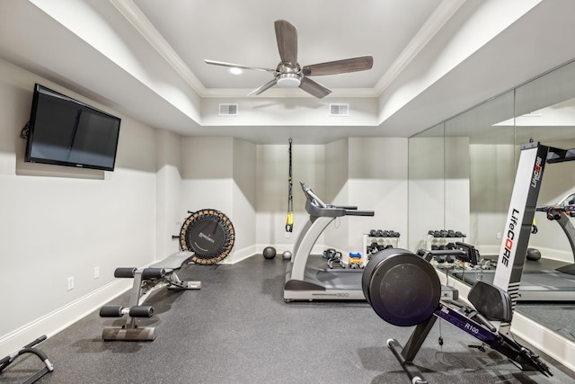 workout area with ceiling fan, crown molding, and a raised ceiling