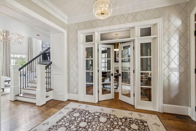 doorway with hardwood / wood-style floors, an inviting chandelier, french doors, and ornamental molding