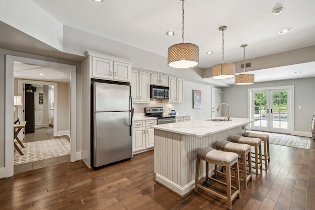 kitchen featuring sink, white cabinetry, a kitchen island with sink, and appliances with stainless steel finishes