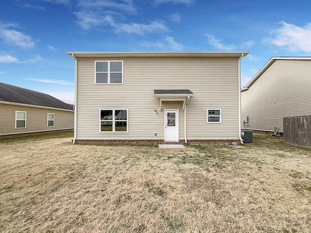 back of property with central air condition unit and a yard