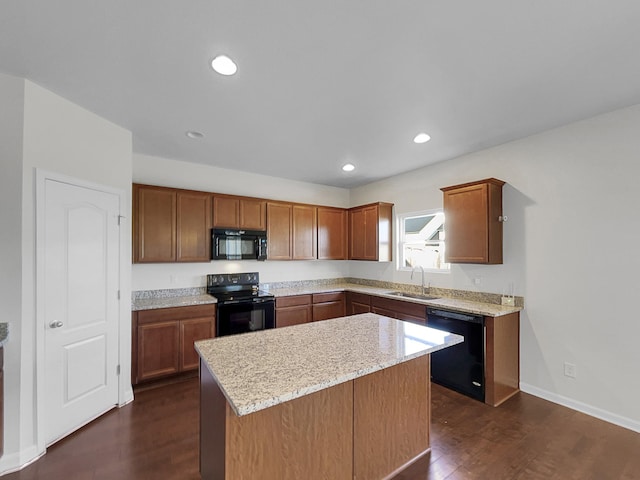 kitchen featuring light stone countertops, black appliances, a center island, dark wood-type flooring, and sink