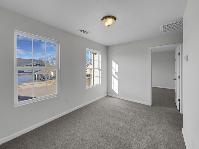 unfurnished room with dark carpet