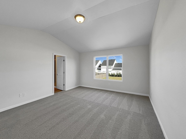 empty room featuring carpet and lofted ceiling