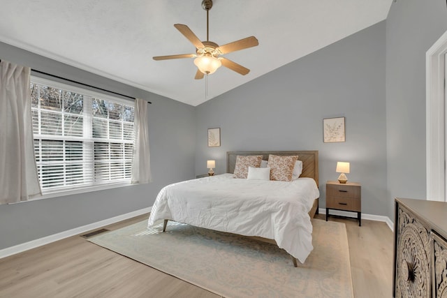 bedroom featuring light wood-type flooring, ceiling fan, and vaulted ceiling