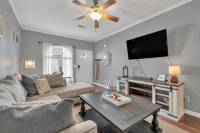 living room with hardwood / wood-style flooring, crown molding, and ceiling fan