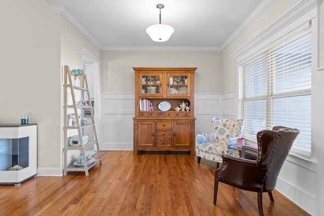 living area featuring hardwood / wood-style flooring, crown molding, and plenty of natural light