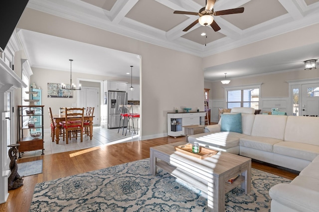 living room featuring beamed ceiling, crown molding, coffered ceiling, light hardwood / wood-style flooring, and ceiling fan with notable chandelier