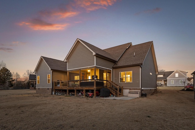 back house at dusk with a wooden deck