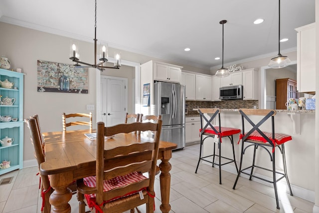 dining space with a notable chandelier and ornamental molding