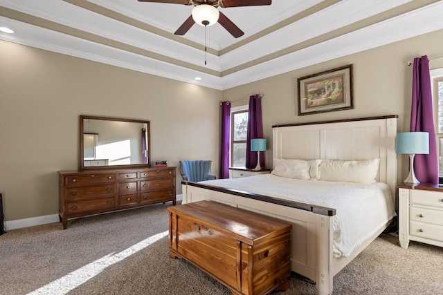 carpeted bedroom featuring ceiling fan, a tray ceiling, and ornamental molding