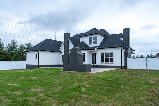 back of property with a lawn and a patio