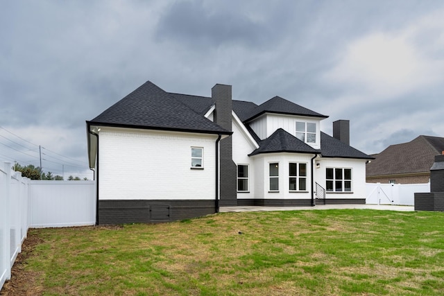 back of property featuring a patio area and a yard