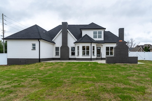 back of property with a lawn and a patio