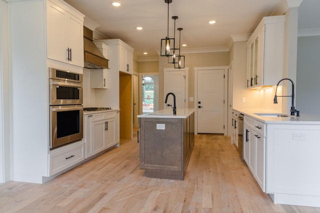 kitchen with sink, white cabinets, a kitchen island with sink, and appliances with stainless steel finishes