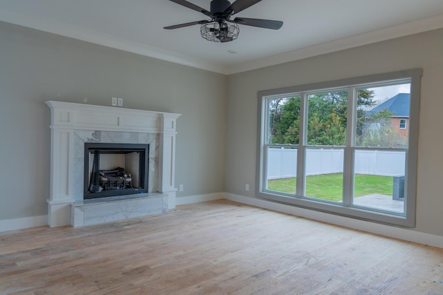 unfurnished living room with ceiling fan, ornamental molding, and a fireplace