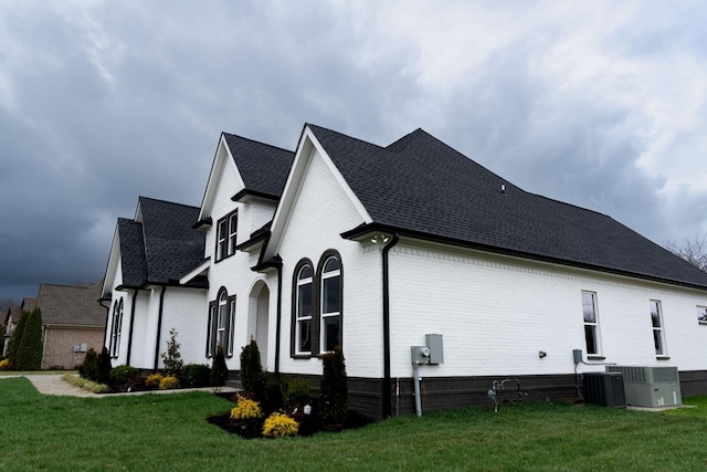 view of property exterior with cooling unit and a yard