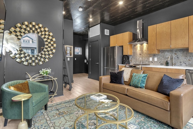 living room with light hardwood / wood-style floors and sink