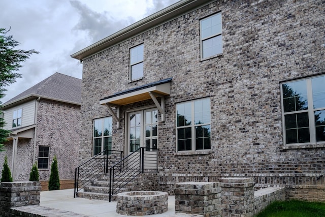 view of front of house with a fire pit and a patio