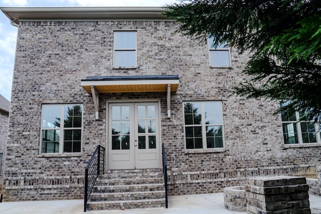 view of exterior entry with a patio area and french doors