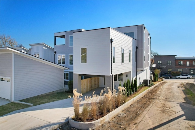 view of front of property featuring central AC and a carport