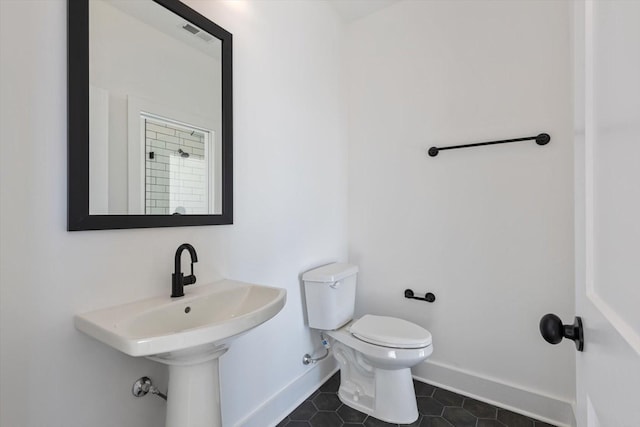 bathroom with sink, toilet, and tile patterned flooring