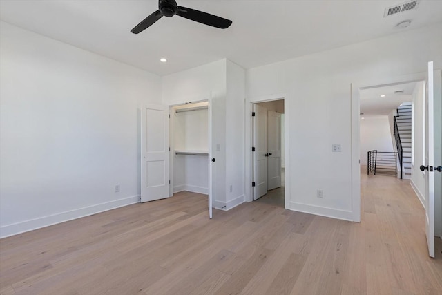 unfurnished bedroom with light wood-type flooring, a closet, and ceiling fan