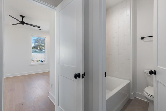 bathroom featuring ceiling fan, hardwood / wood-style floors, and toilet