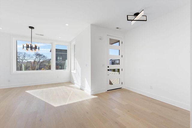 interior space with a notable chandelier and light wood-type flooring